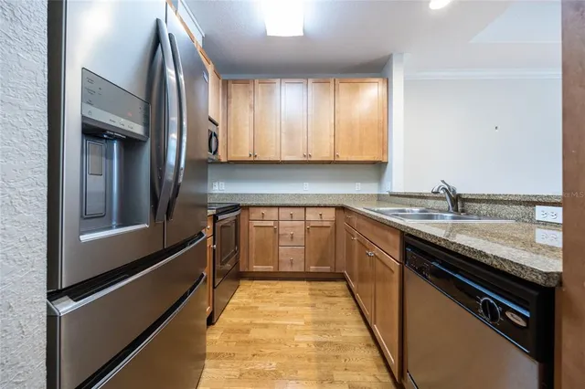 a kitchen with stainless steel appliances granite countertop a sink and a stove