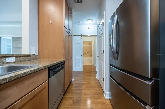 a view of a refrigerator a sink and cabinets
