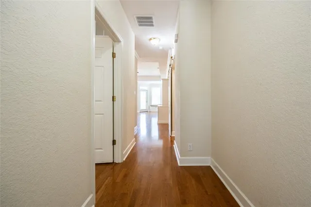 a view of a hallway with wooden floor