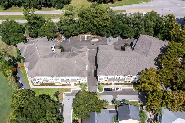 an aerial view of residential house with outdoor space and trees all around