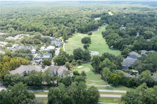 an aerial view of residential houses with outdoor space and trees all around