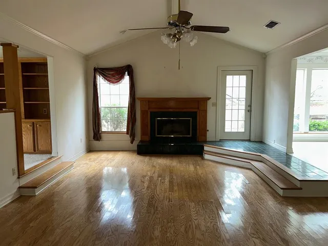 a view of an empty room with window and fire place