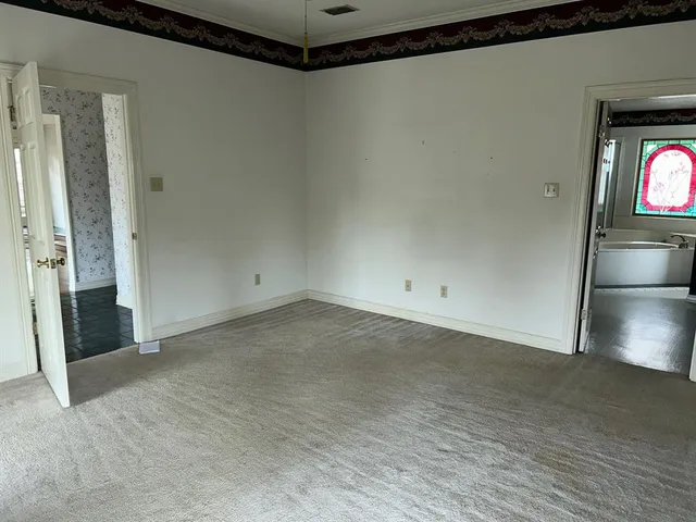 a view of a room with wooden floor and hallway