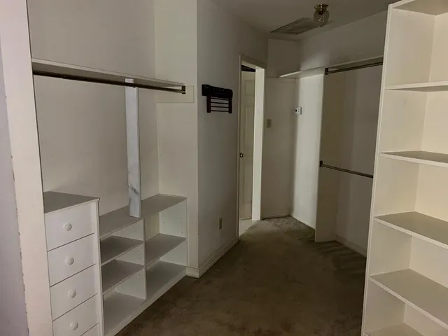 a view of walk in closet with empty racks
