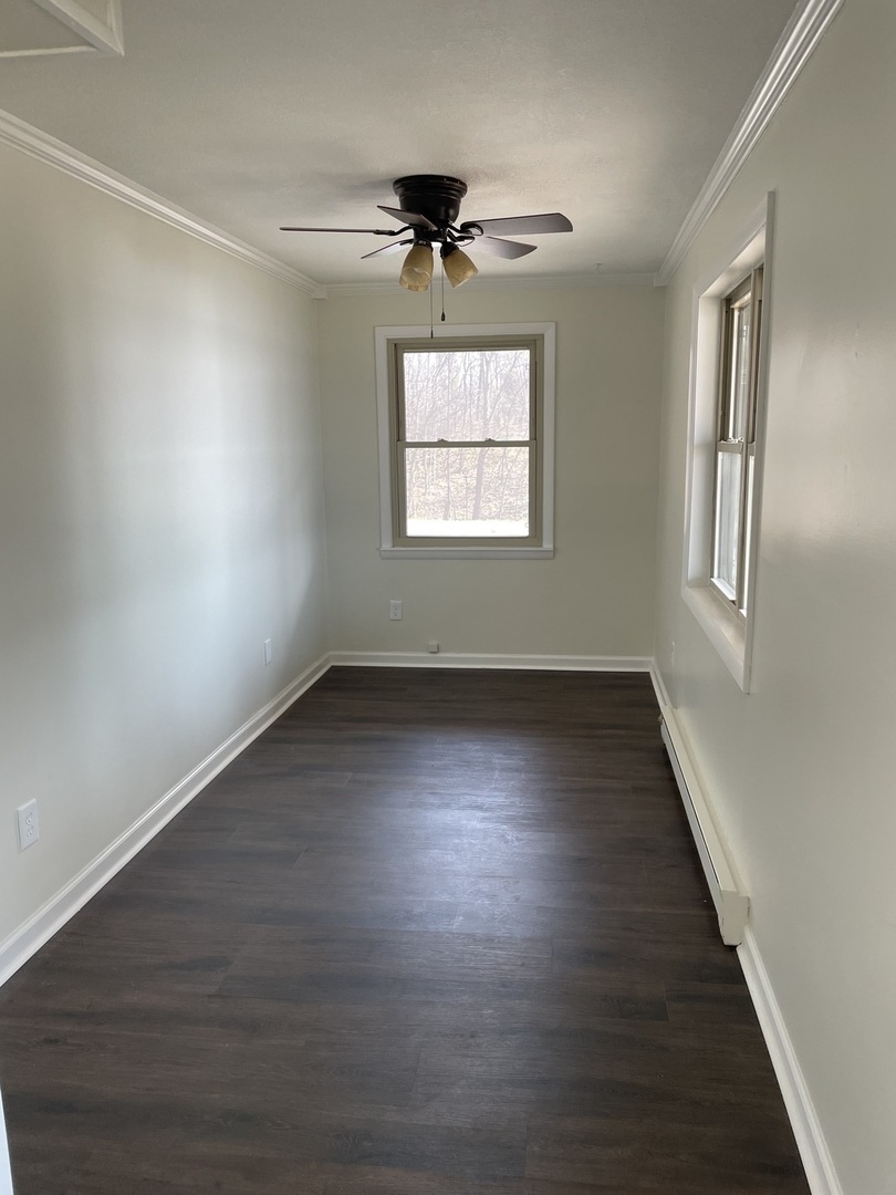 3512 Riverview Lake Road Metropolis, IL 62960 - Photo 4 of 20 an empty room with wooden floor chandelier fan and windows