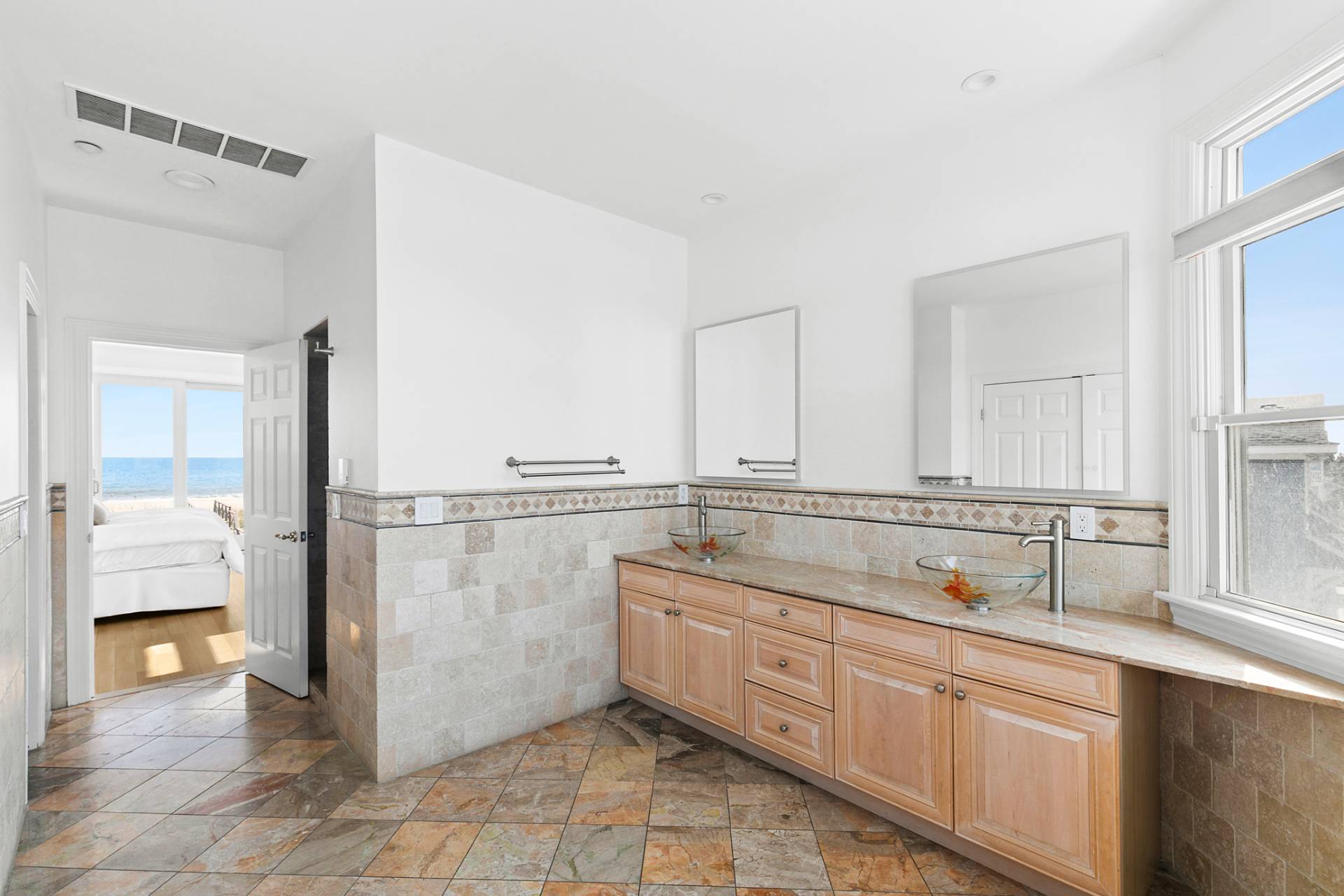 687 Dune Road Westhampton Beach, NY 11978 - Photo 15 of 24 a bathroom with a double vanity sink a mirror and a bathtub