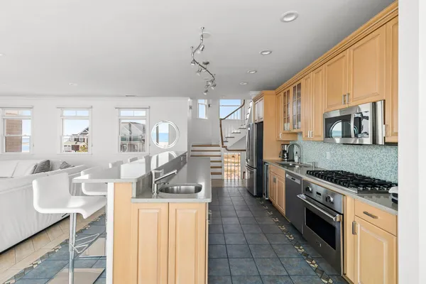 a kitchen with stainless steel appliances a stove sink microwave and cabinets