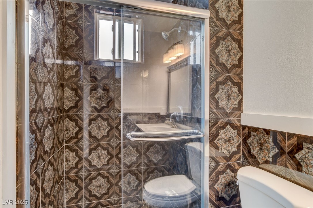 4430 Eureka Circle Las Vegas, NV 89103 - Photo 30 of 39 Bathroom with tile walls, toilet, and a stall show
