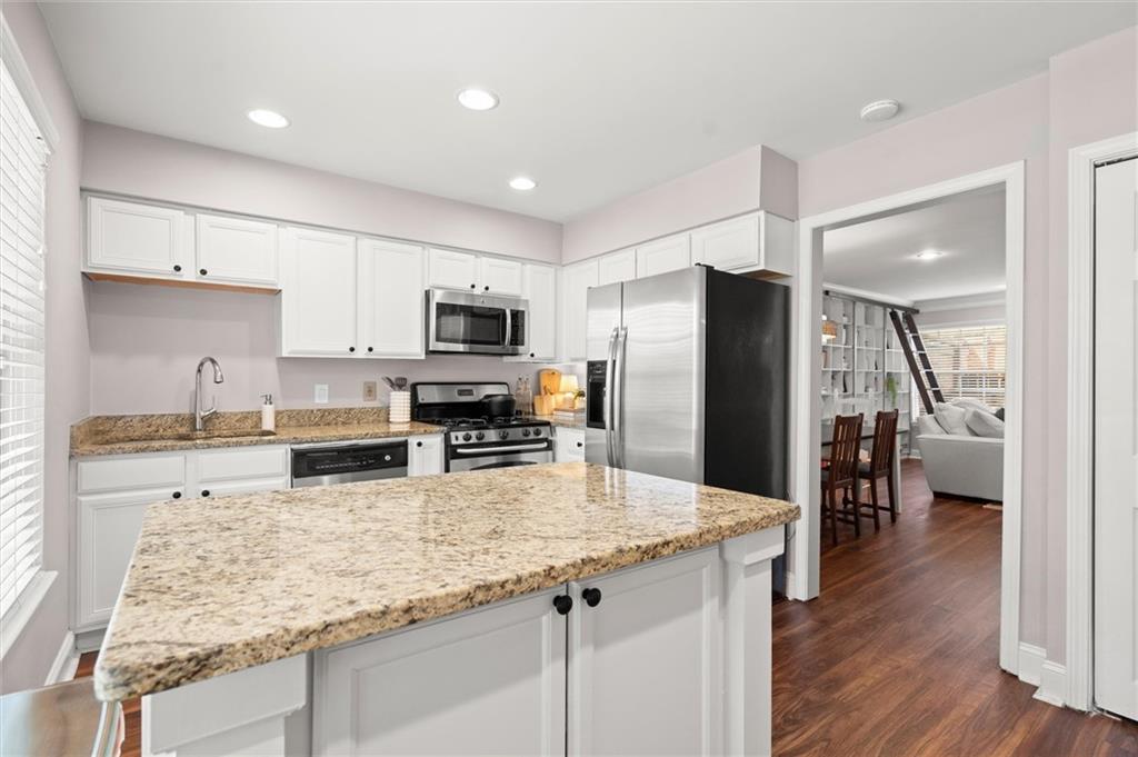 6980 Roswell Road, Unit F7 Atlanta, GA 30328 - Photo 15 of 43 a kitchen with stainless steel appliances granite countertop a refrigerator stove microwave and sink