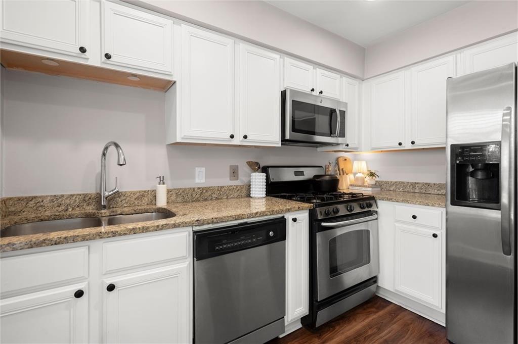 6980 Roswell Road, Unit F7 Atlanta, GA 30328 - Photo 16 of 43 a kitchen with stainless steel appliances granite countertop a sink a stove and a refrigerator