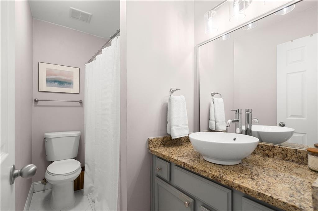 6980 Roswell Road, Unit F7 Atlanta, GA 30328 - Photo 24 of 43 a bathroom with a granite countertop sink and a mirror