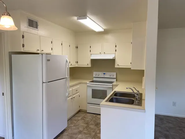 a view of a kitchen with refrigerator and windows
