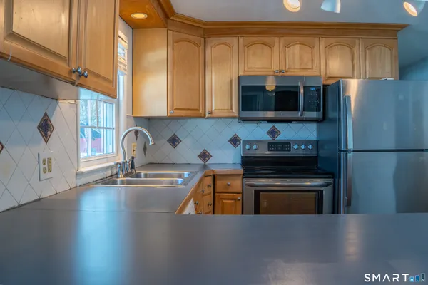 a kitchen with granite countertop a stove a sink and a microwave