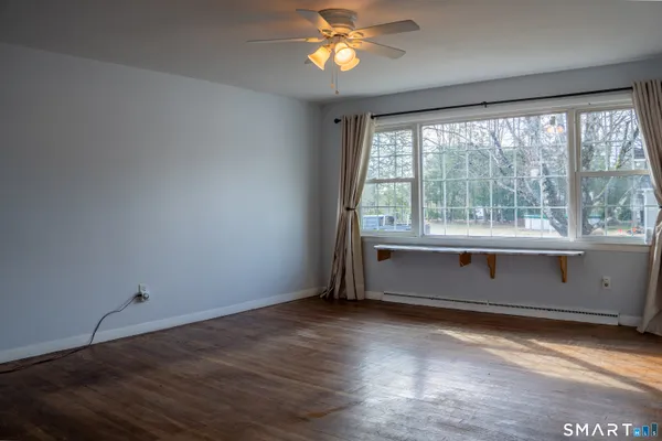 a living room with hardwood floor and a ceiling fan