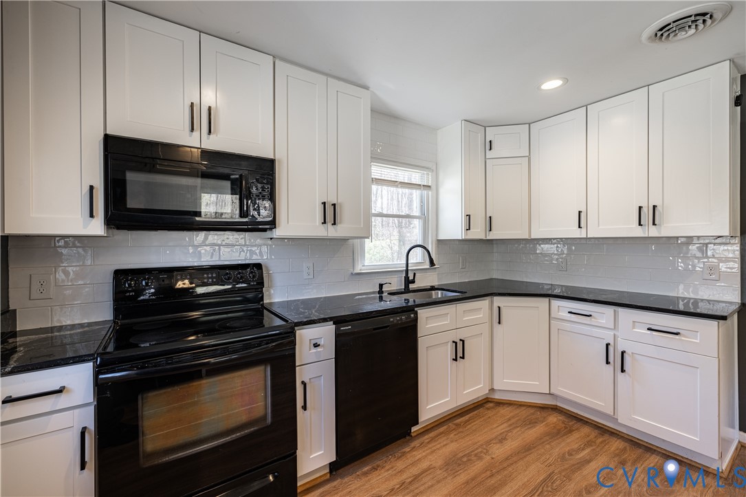 9813 Colemans Lake Road Ford, VA 23850 - Photo 13 of 38 a kitchen with granite countertop a stove top oven a sink dishwasher and cabinets with wooden floor