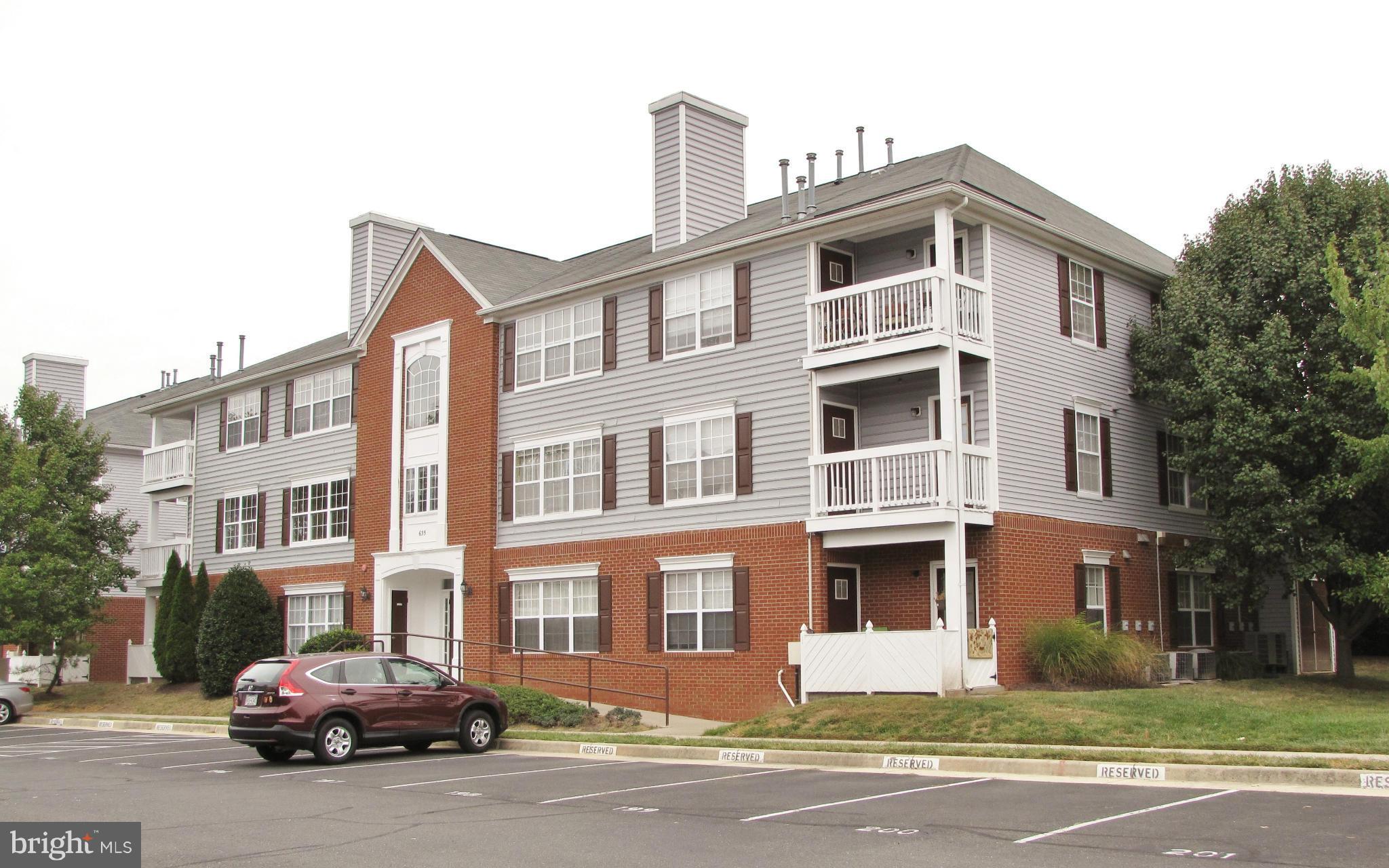 635 Constellation Square Southeast, Unit E Leesburg, VA 20175 - Photo 1 of 20 a front view of a residential apartment building with a yard