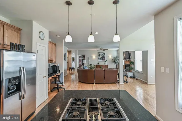 a kitchen with stainless steel appliances granite countertop a sink a refrigerator and a stove