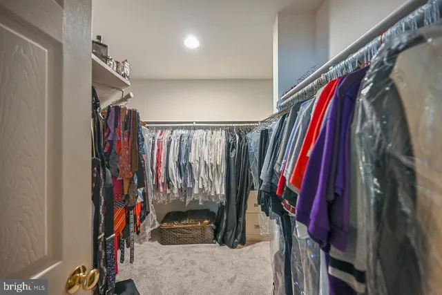 a view of a walk in closet with clothes