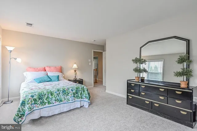 a bedroom with a bed and a dresser in it