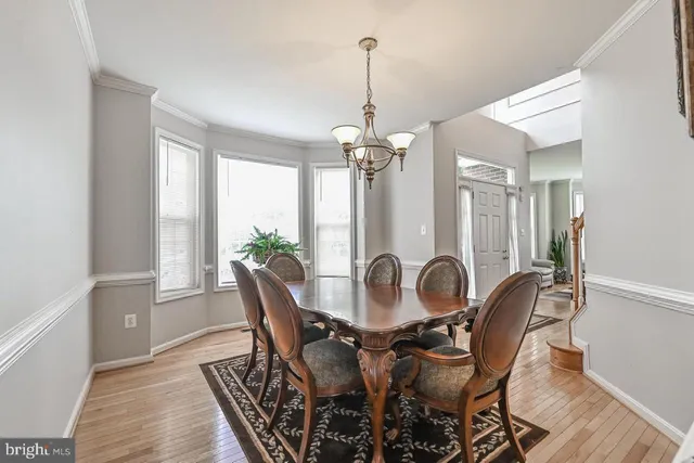 a dining room with furniture a chandelier and wooden floor