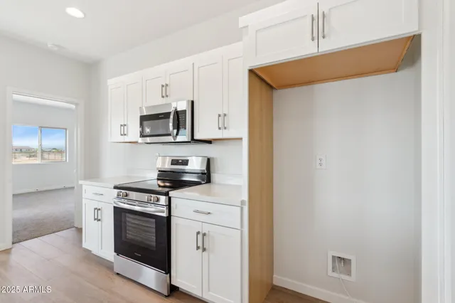 a kitchen with cabinets and wooden floor