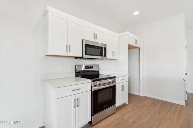 a kitchen with granite countertop white cabinets and white appliances