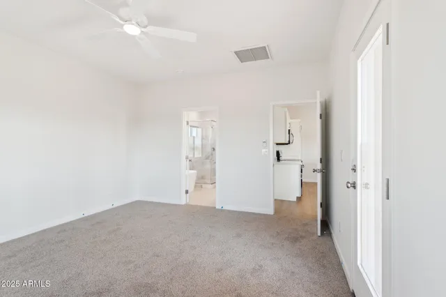 an empty room with fan and entrance