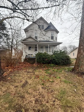 a front view of house with yard and trees around