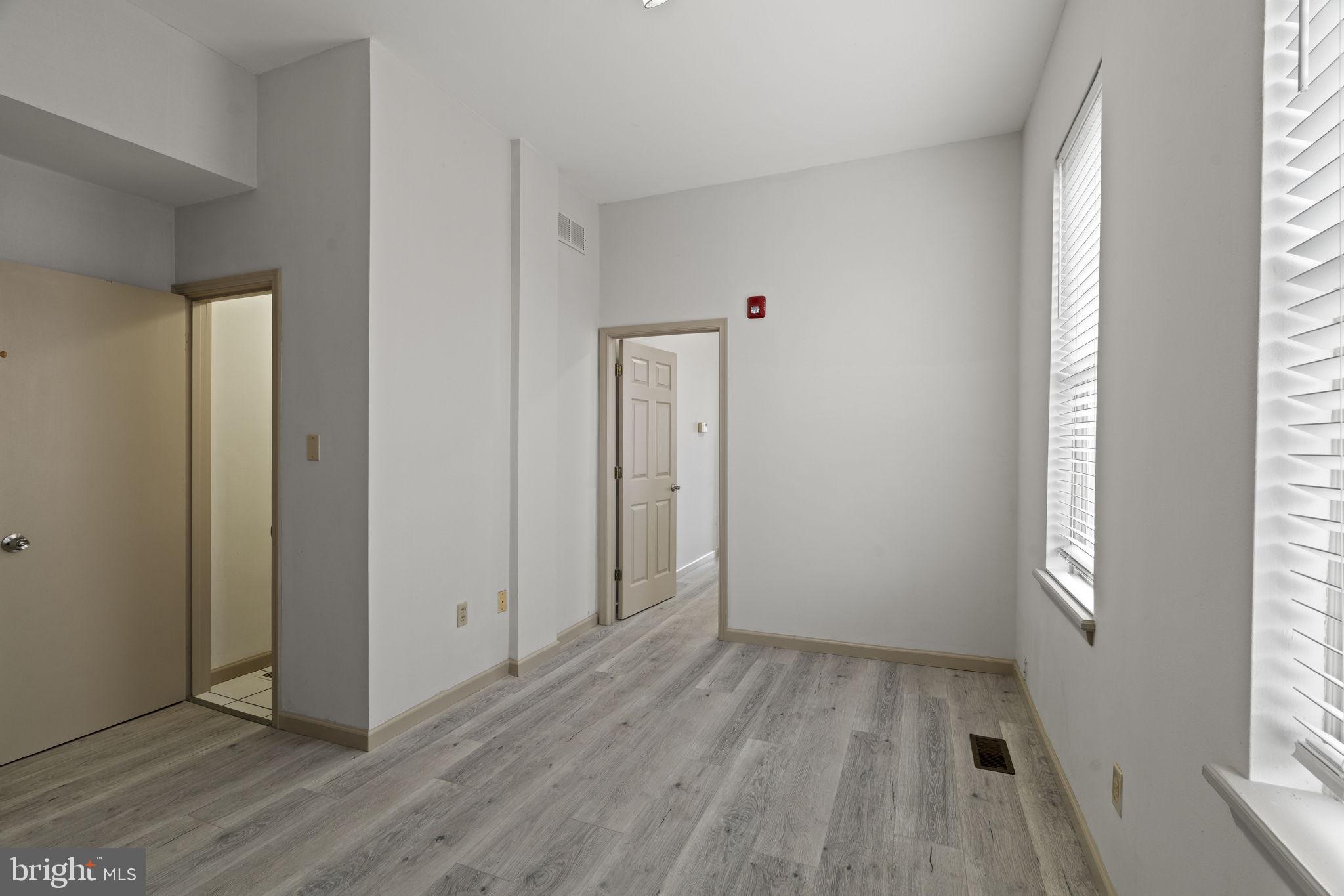 2626 East Allegheny Avenue Philadelphia, PA 19134 - Photo 7 of 32 an empty room with wooden floor and windows