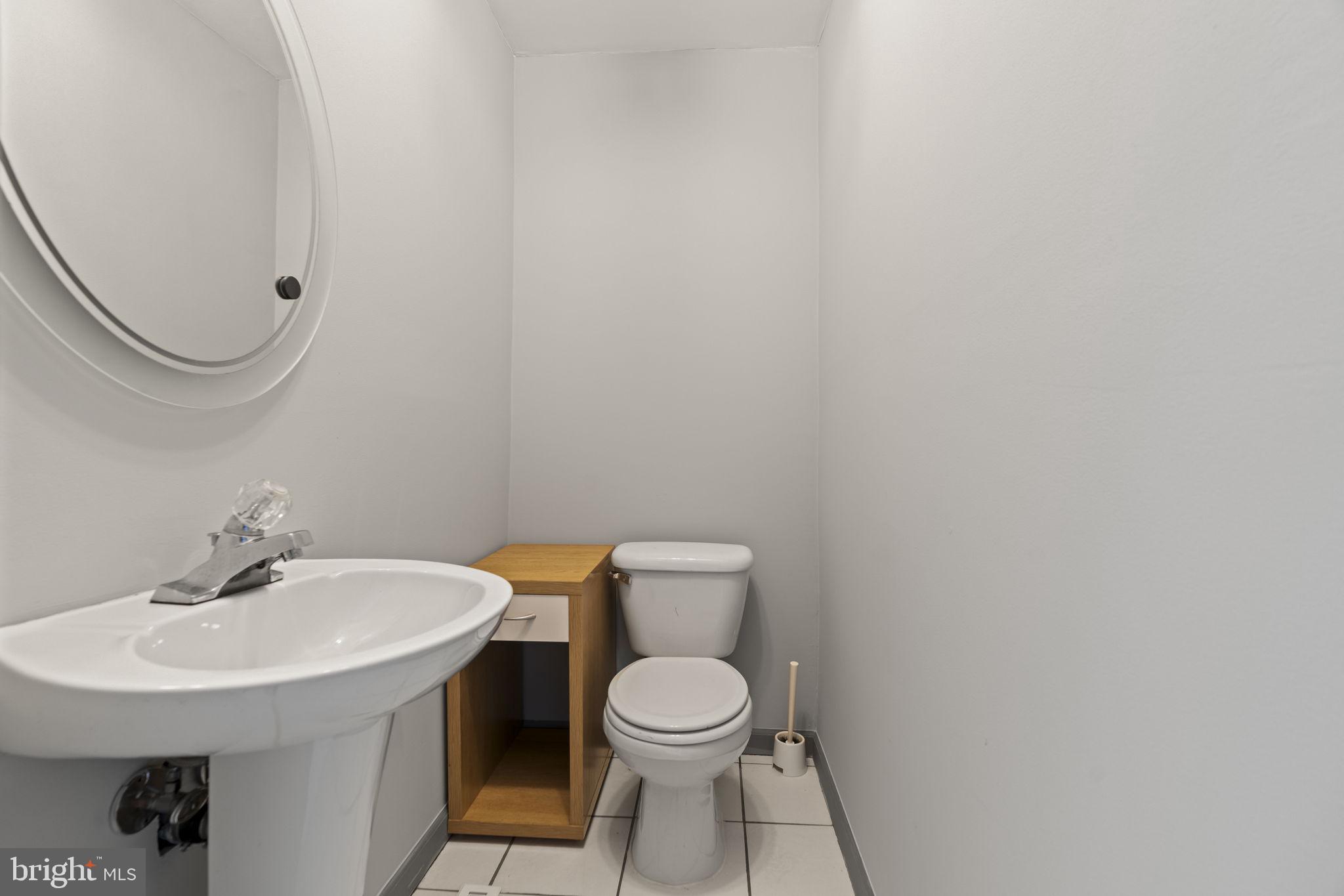 2626 East Allegheny Avenue Philadelphia, PA 19134 - Photo 10 of 32 a bathroom with a toilet a sink and a mirror