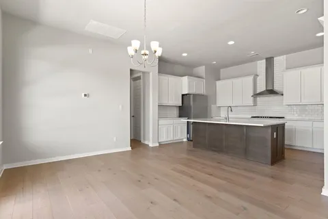 a view of kitchen with granite countertop cabinets and refrigerator