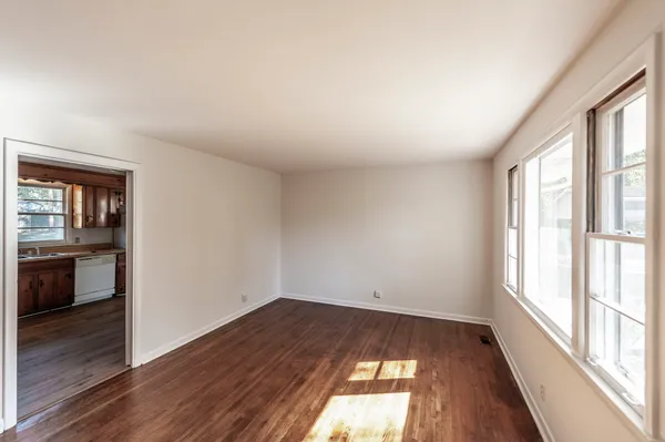 a kitchen with stainless steel appliances a stove top oven a refrigerator a sink and dishwasher with wooden floor