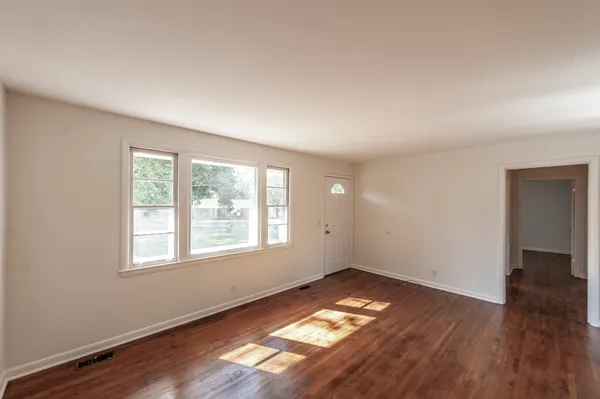 a view of a dining room with furniture a kitchen and wooden floor