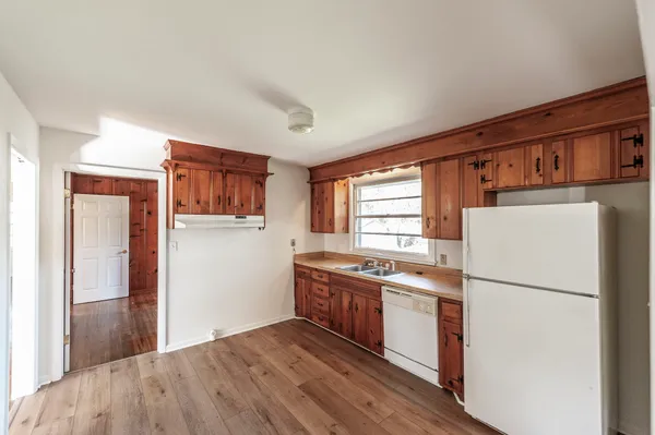 an empty room with wooden floor and fireplace