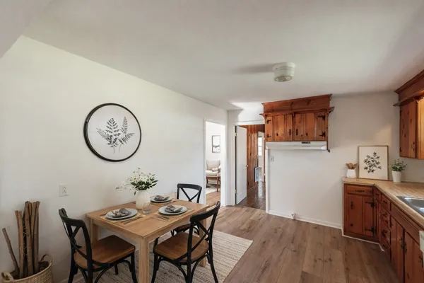 an empty room with wooden floor fireplace and windows
