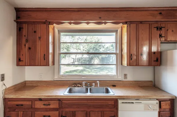 an empty room with windows fireplace and fan