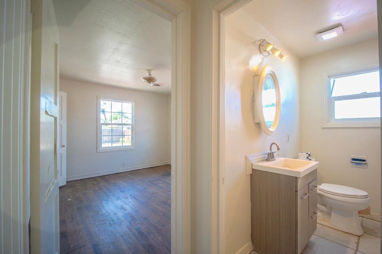 214 Ferguson Avenue Modesto, CA 95354 - Photo 9 of 14 a bathroom with a toilet a sink and mirror