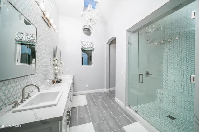 a spacious bathroom with a tub sink and mirror