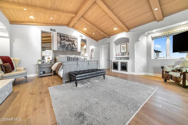 a spacious bedroom with a bed and a fireplace