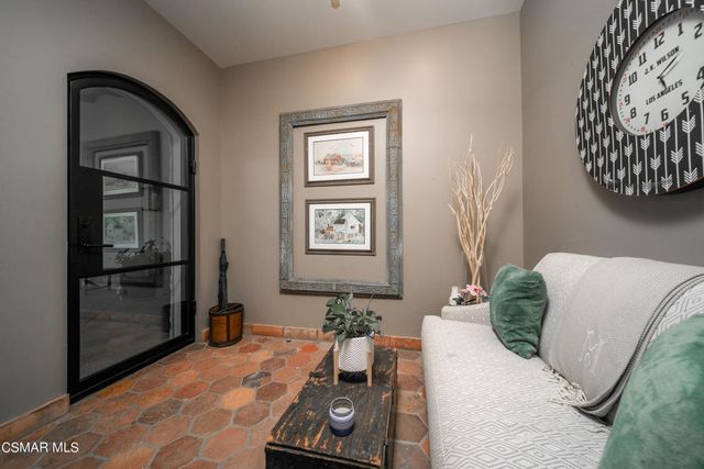 a living room with fireplace furniture and a large window