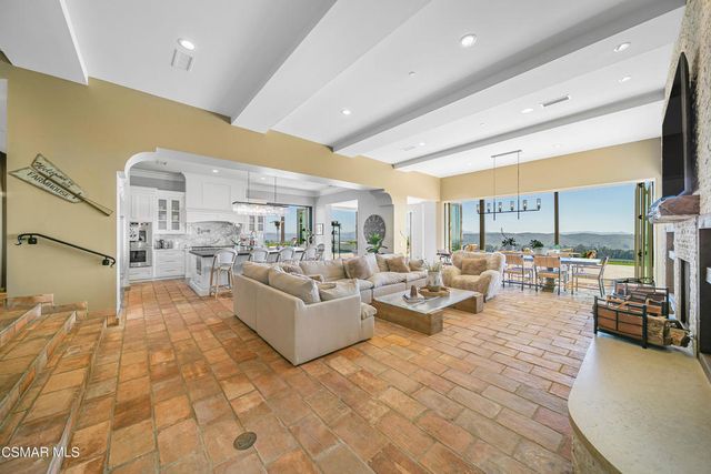 a living room with furniture a large window and a flat screen tv