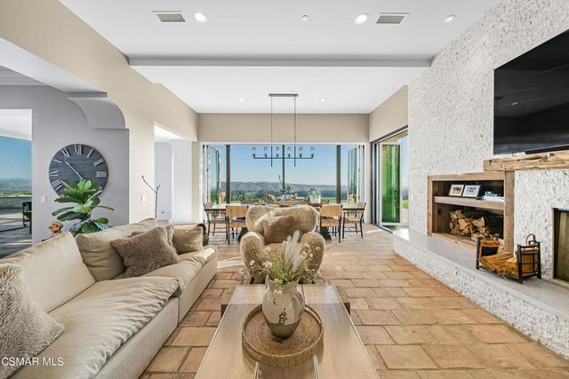 a kitchen with stainless steel appliances granite countertop a stove a sink dishwasher a refrigerator and a dining table with wooden floor