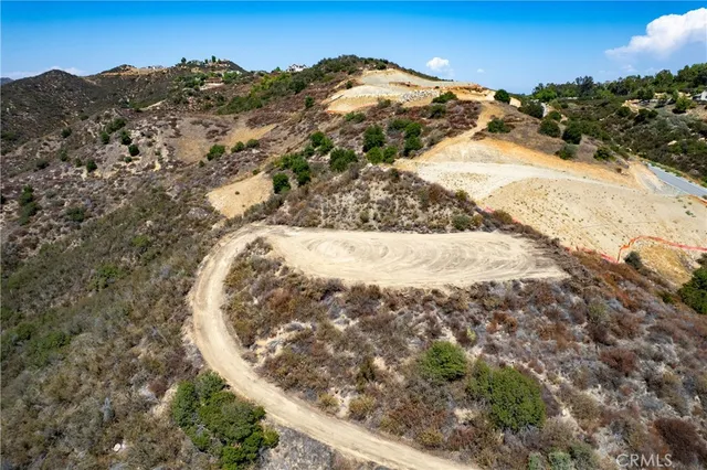 a view of a dry yard with wooden fence