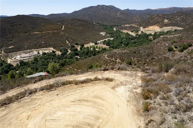 a view of a dry yard with mountains in the background