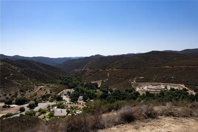 a view of a lush green field with mountains in the background