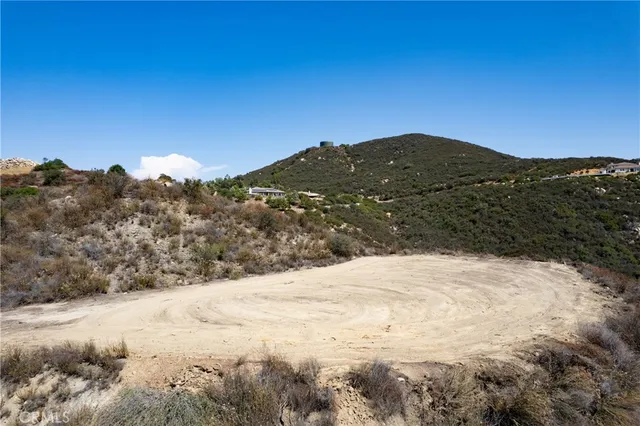 a view of a dry yard with mountains in the background