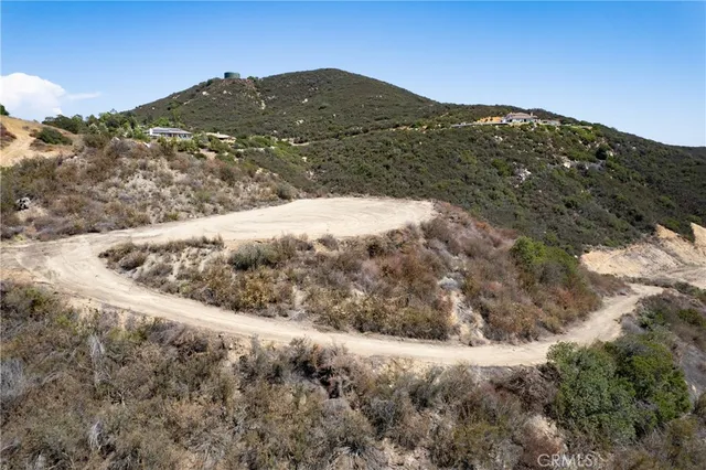 a view of a dry yard with mountains in the background