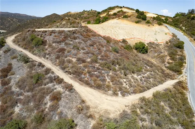 a view of a dry yard with mountains in the background