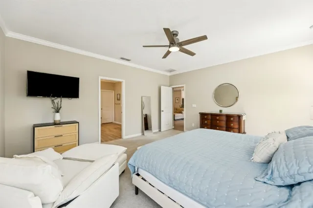 a bedroom with a bed a mirror and a flat tv screen on dresser