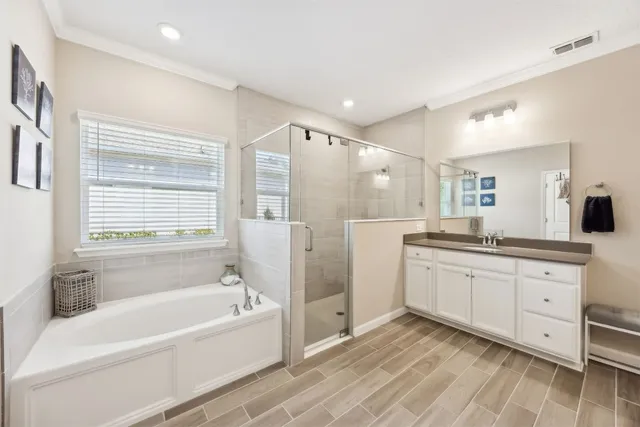 a bathroom with a bathtub a double vanity sink and a window